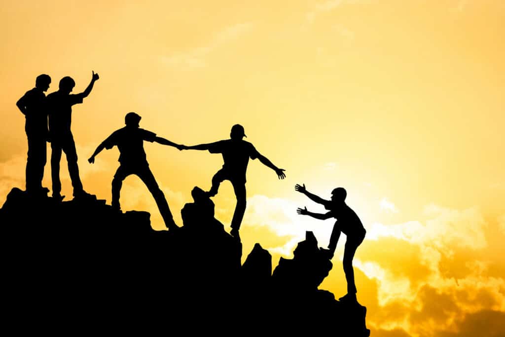 Group of people on peak mountain climbing helping team work