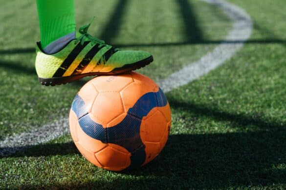 close up of soccer player's foot on top of ball on a field